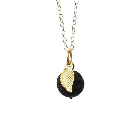 The round lava stone and gold leaf charm that makes up the apple aromatherapy necklace