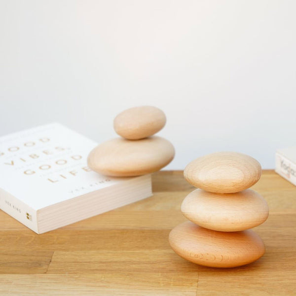Wooden Pebbles stacked on top of a book