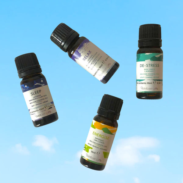 Four essential oil bottles with a blue sky background