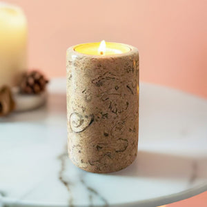 A fossil stone candle on a white marble table