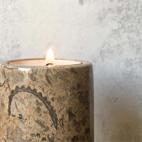A close up of the top of the fossil stone tea light candle, with a lit candle inside