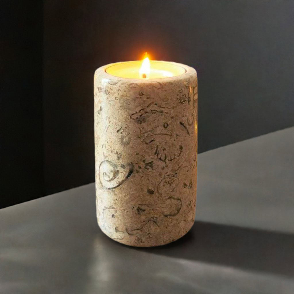 A fossil stone candle on a grey shelf