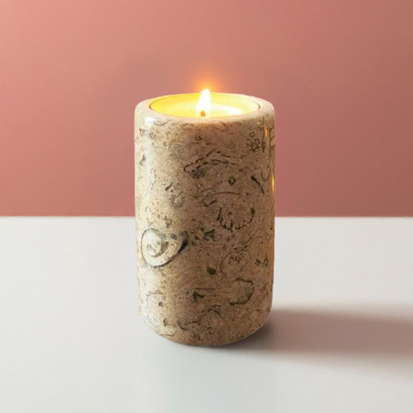 A fossil stone candle on a white 
table