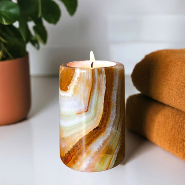 An onyx stone candle on a bathroom shelf with a towel