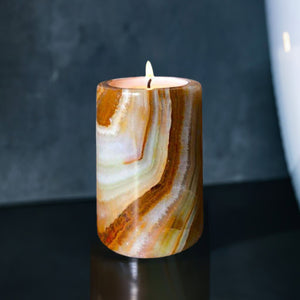 An onyx stone candle in a dark coloured bathroom