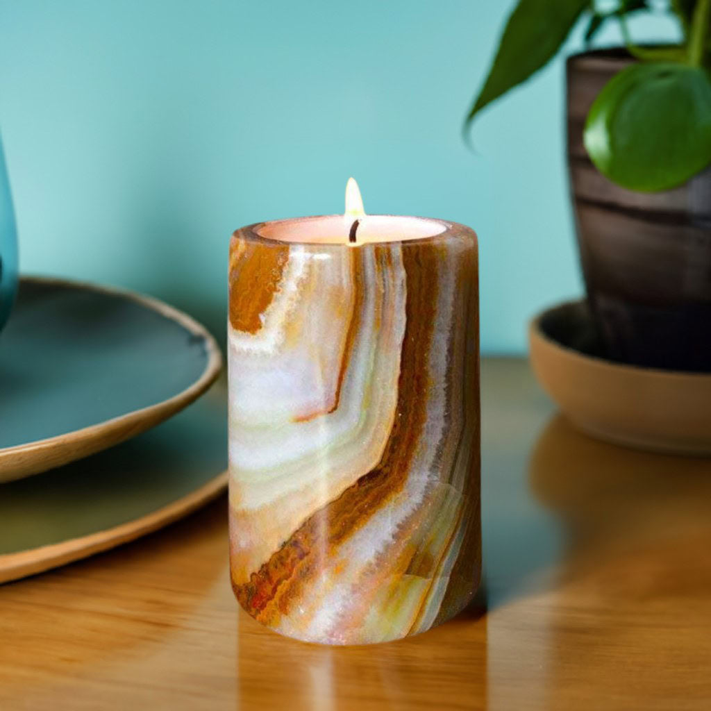 An onyx stone candle on a table with a plant