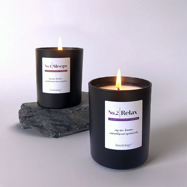 Two essential oil candle jars on slate stone