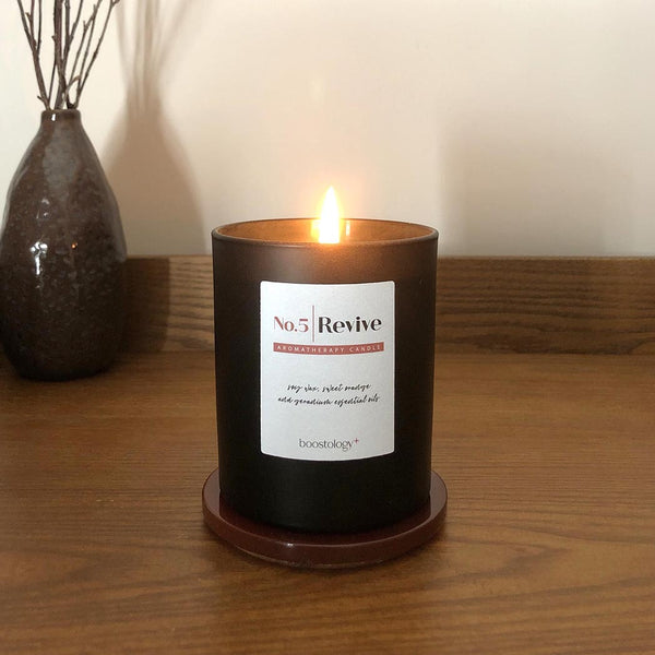 A soy wax candle on a wooden bedside cabinet