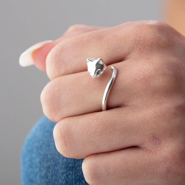 A woman wearing a silver cat ring on her finger