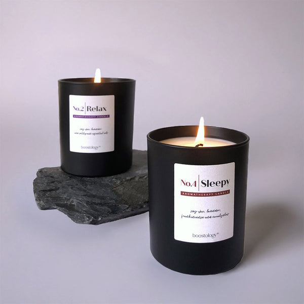 Two lit essential oil candles on slate stone