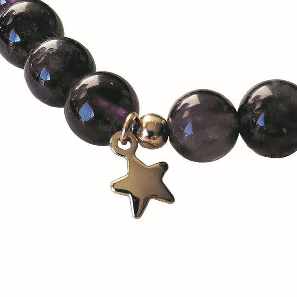 A close up showing the gold star charm on the diffuser bracelet 