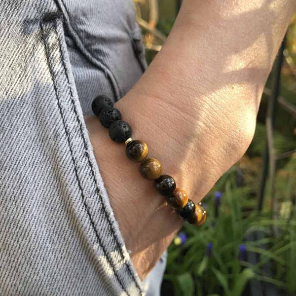 A woman wearing a brown tigers eye diffuser bracelet