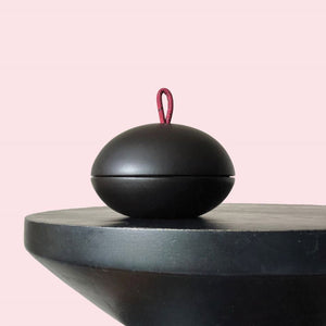 A lava rock diffuser on a black side table